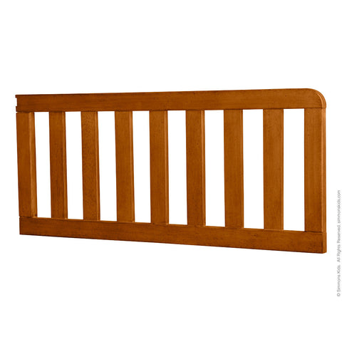 a light brown wooden crib rail